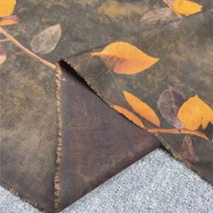 This is a coffee-colored base yellow leaf floral gauze perforated fabric for halter dress and coat